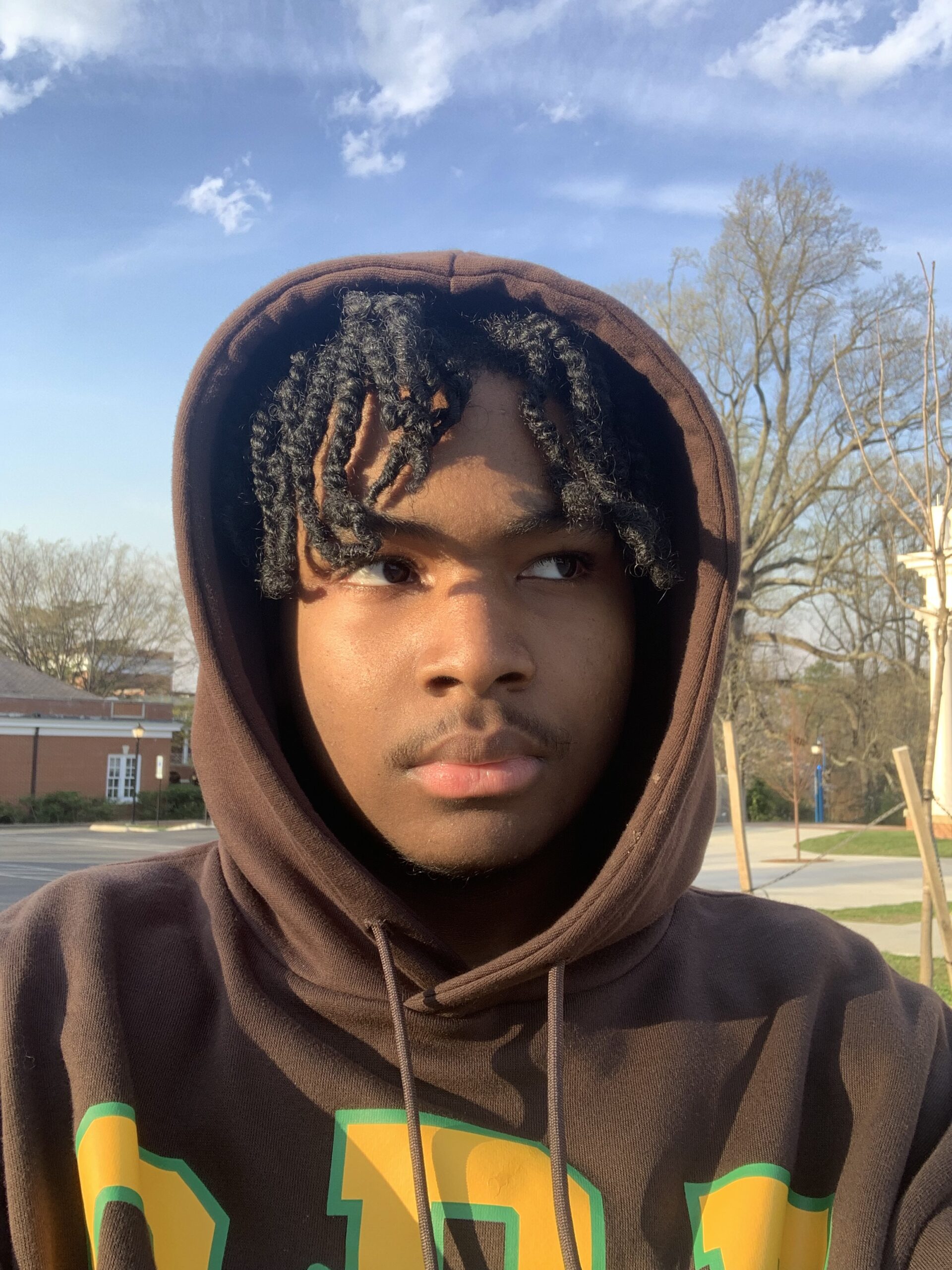 A picture of Joel Lamonth wearing a brown hoodie gazing off in another direction